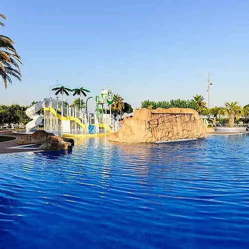 Estival Eldorado Resort: Piscina blava amb tobogans i casc natural. Reserva al lloc web oficial Estival Group.