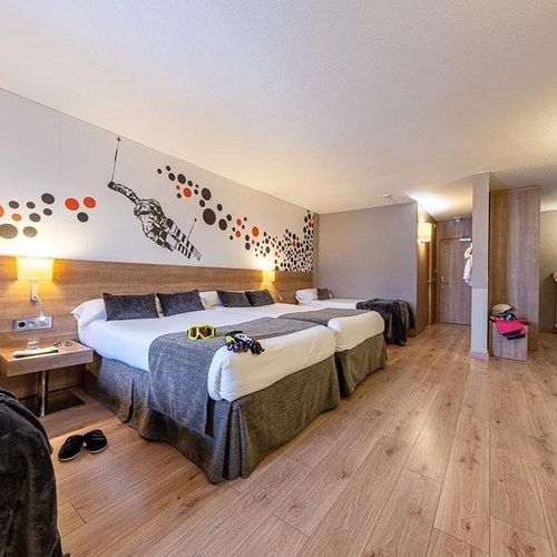 a hotel room with three beds and a painting on the wall