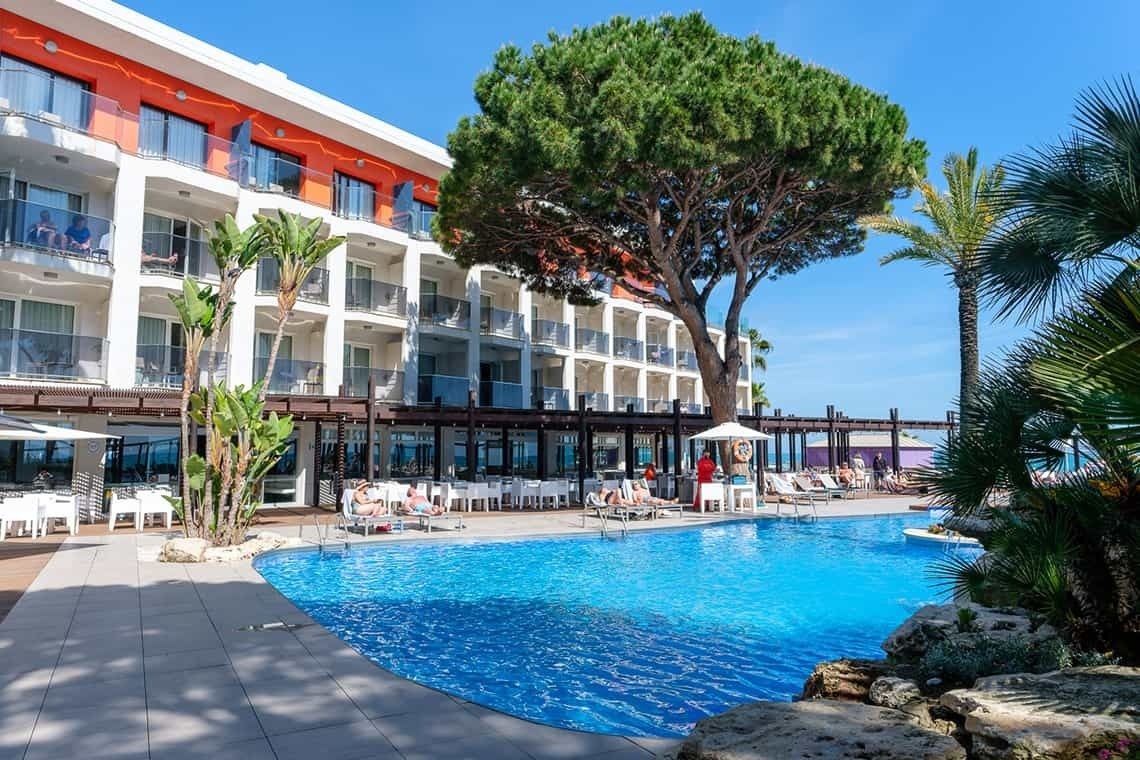 a large swimming pool in front of a hotel