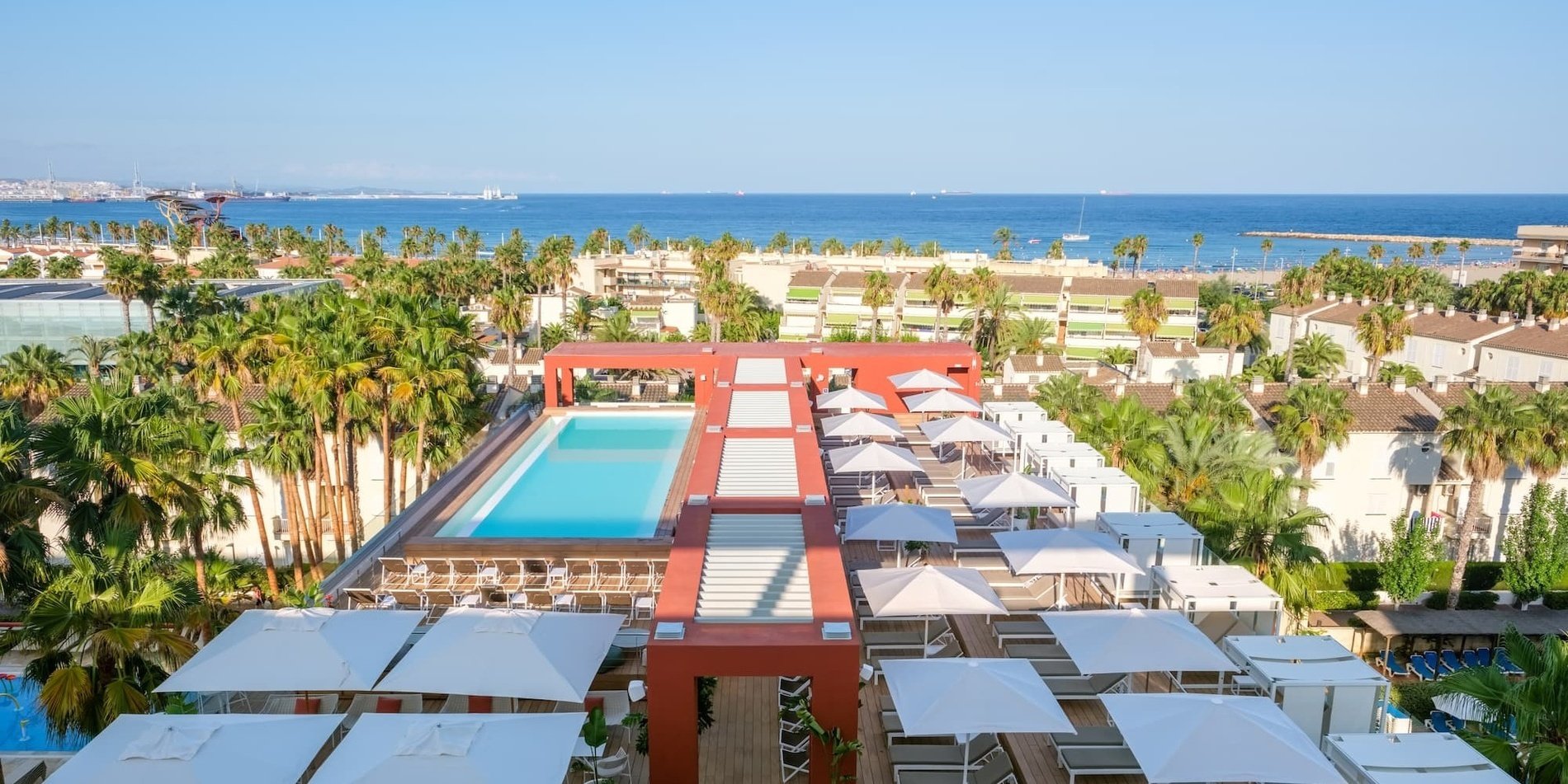 una vista aèria d' un hotel amb una piscina i parasols