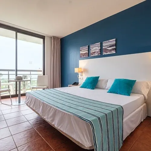 Estival Islantilla 4* | Huelva: Modern hotel room with balcony, large bed, and blue accents. Official Web.