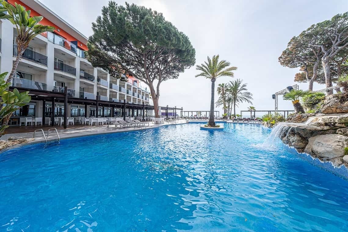 a large swimming pool in front of a hotel