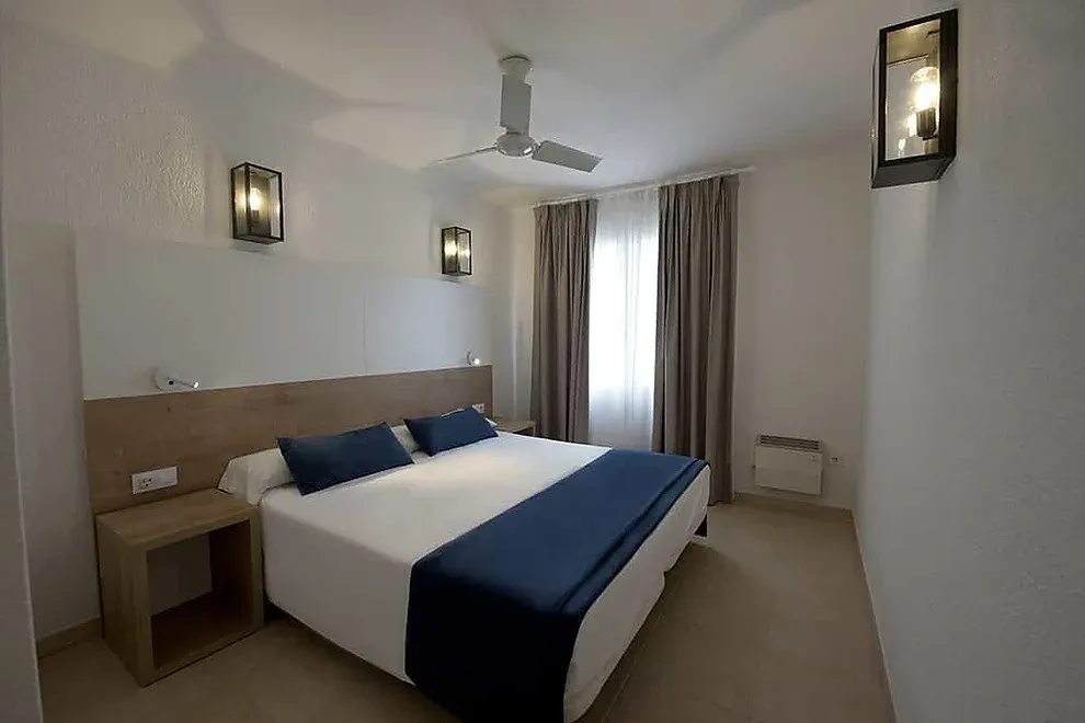 Habitación moderna ESTIVAL: Corporativa con cama doble y detalles acogedores.