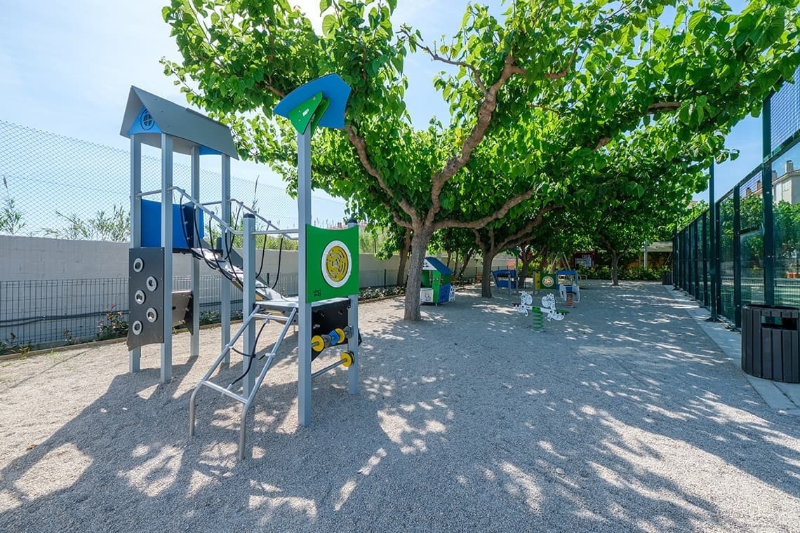 un área de juegos para niños en un parque con árboles