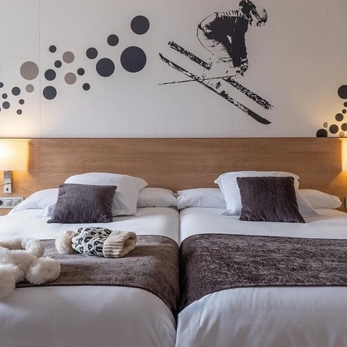 a hotel room with two beds and a skier on the wall