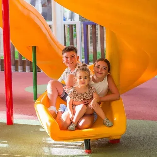 Germans somrients en tobogan groc, ideal per vacances ESTIVAL: Corporativa.