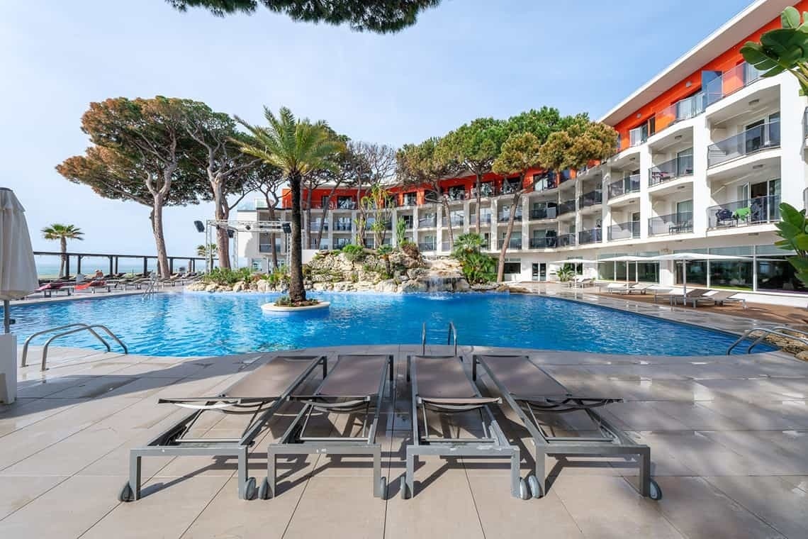 a large swimming pool in front of a hotel