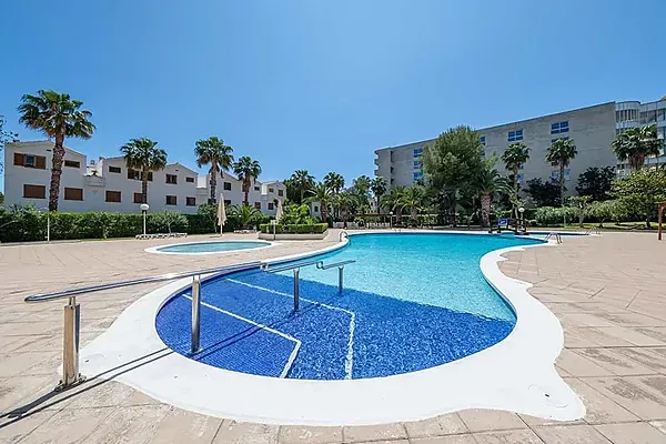 ESTIVAL: Piscina amb palmeres i edificis, ideal per a estades corporatives.