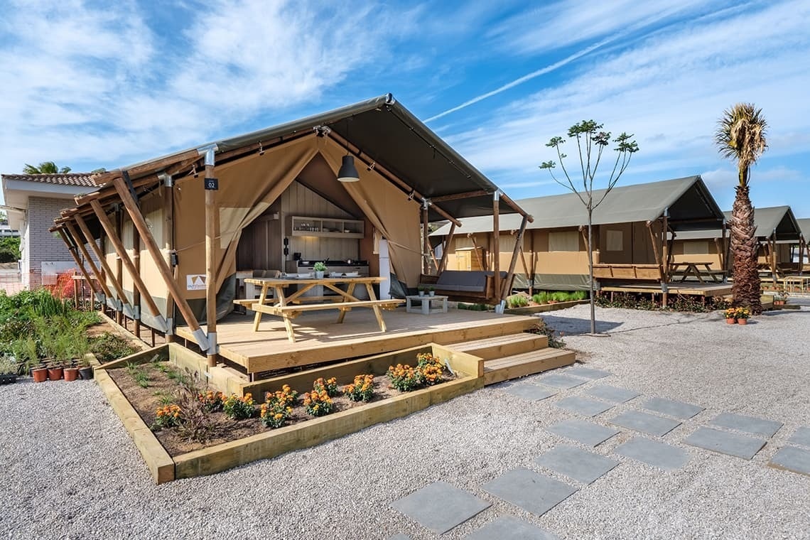 a tent with a kitchen and a picnic table outside