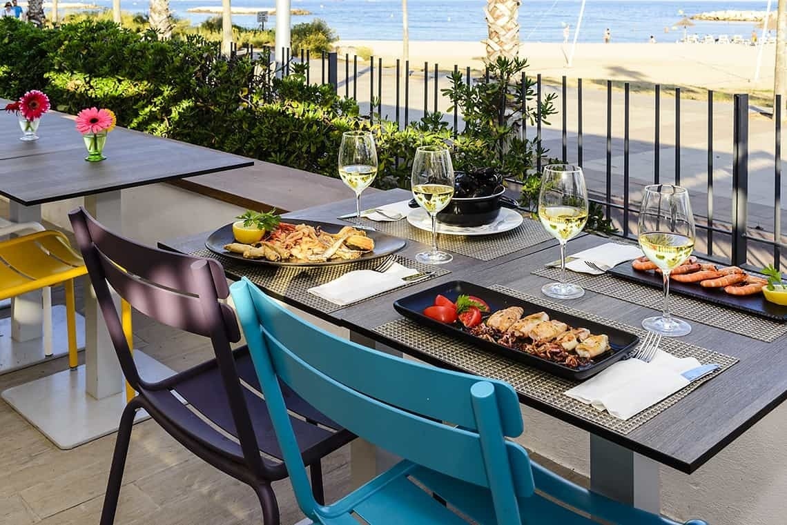Comida de mariscos y vino en terraza con vista al mar. Estival Eldorado Resort | Estival Group.