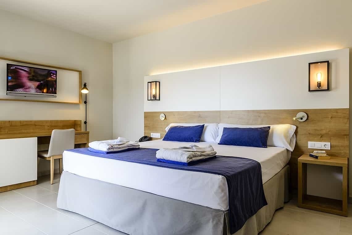 Habitación de lujo Estival Eldorado Resort: cama doble, TV y escritorio.