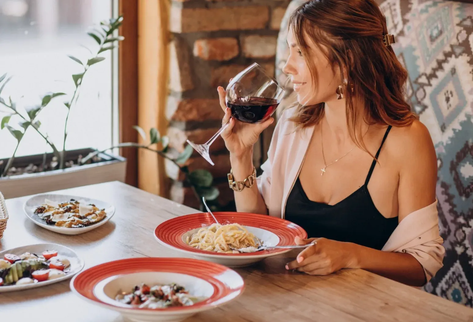 Mujer disfrutando vino y pasta en ESTIVAL: Corporativa.