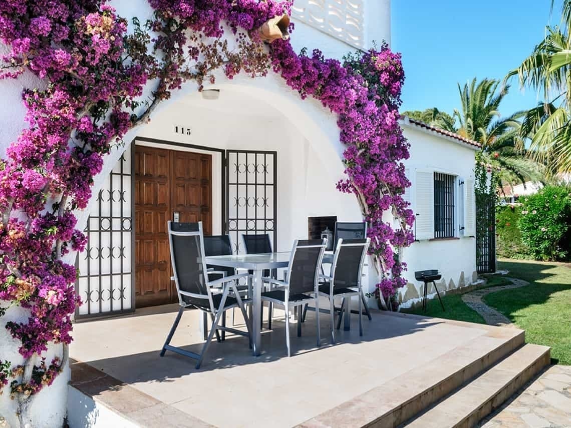 Terraza Estival Eldorado Resort con buganvillas, mesa y sillas. ¡Reserva online!
