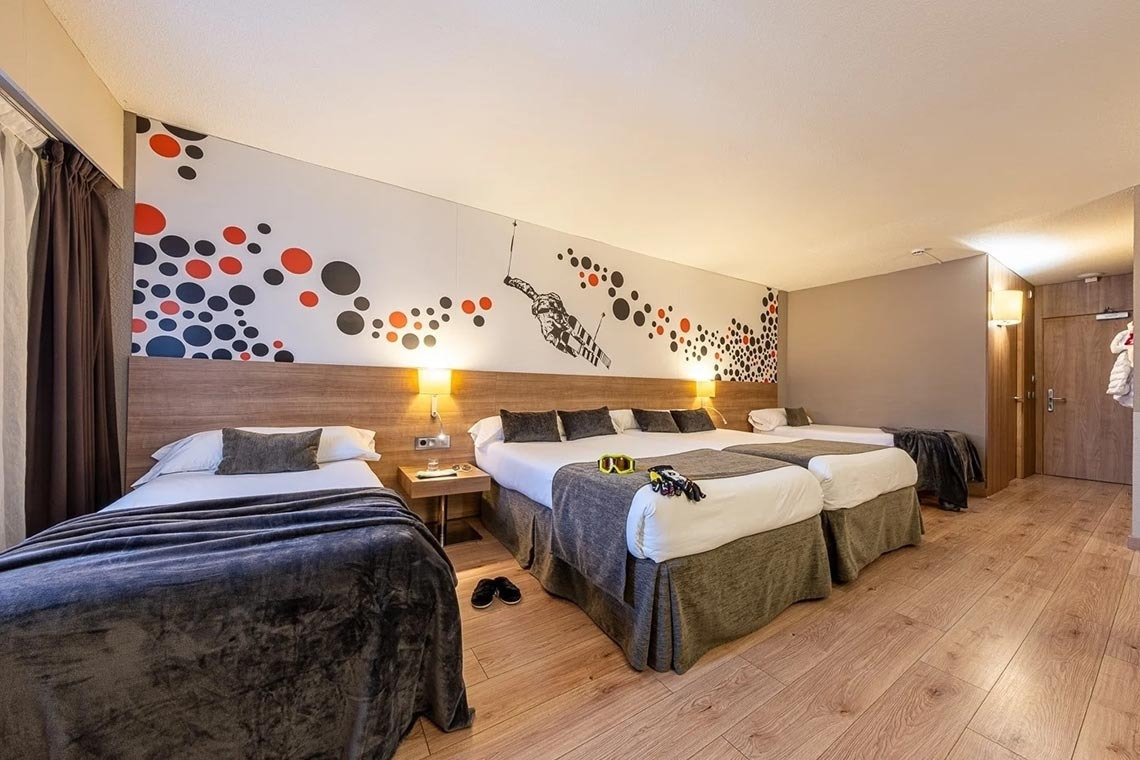 una habitació d' hotel amb tres camas i un mural a la paret
