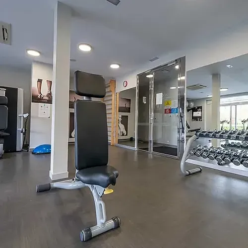 ESTIVAL: Corporate gym with weights, benches, and exercise machines.