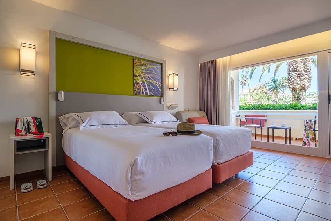 ESTIVAL: Corporativa Zimmer mit zwei Betten, Balkon und Palmenblick.