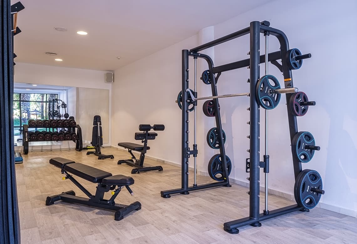 a gym with a smith machine and a bench