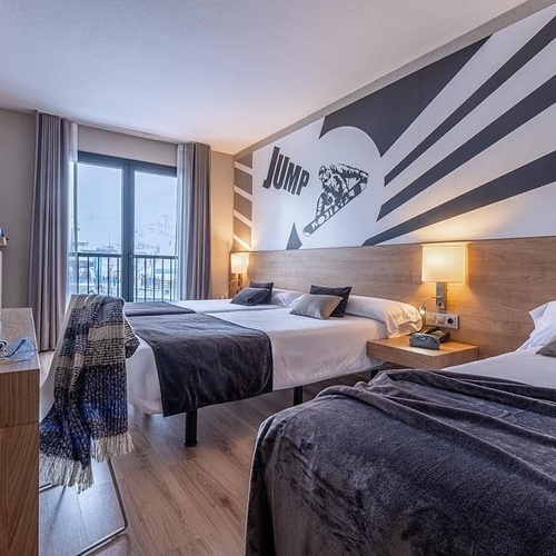 a hotel room with two beds and a painting on the wall that says jump