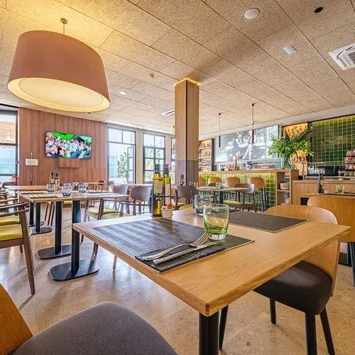 ESTIVAL: Corporate Restaurant. Wooden tables and comfortable chairs in the dining area.