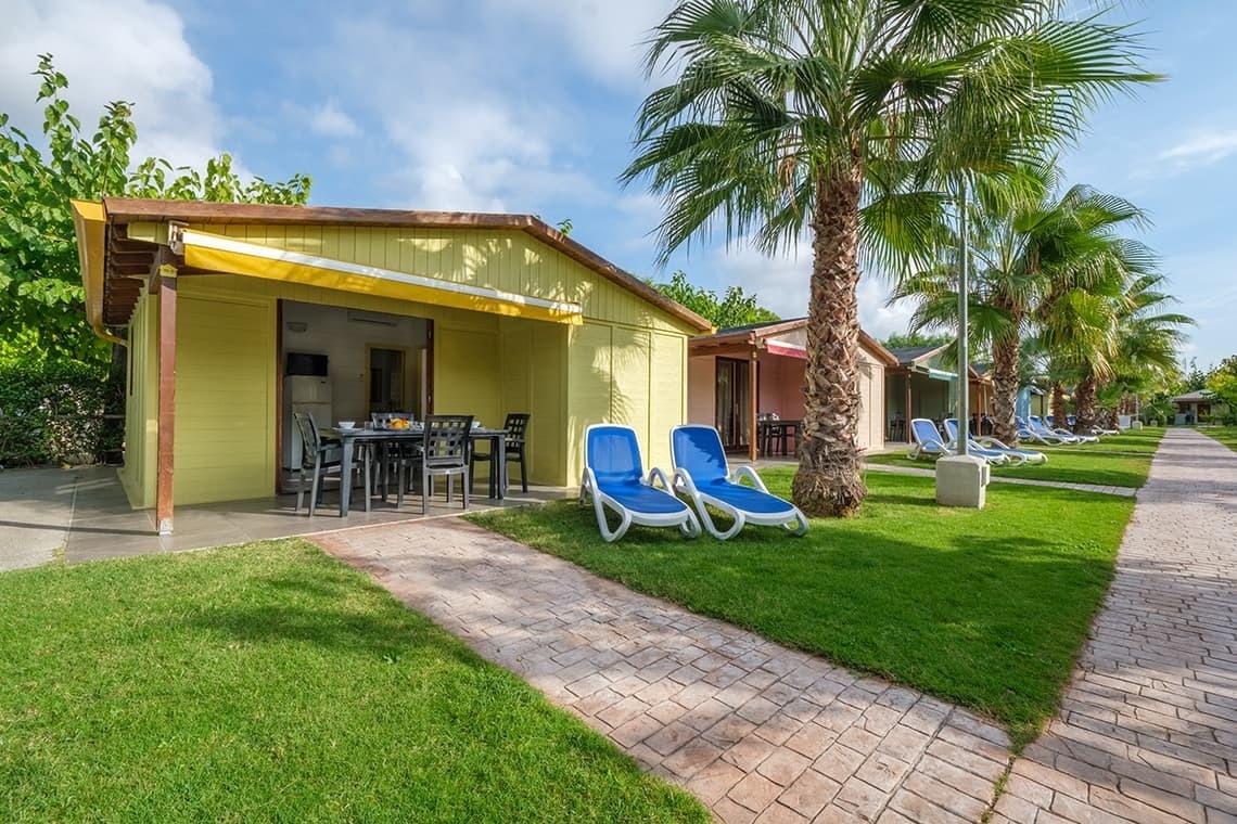 a yellow house with a table and chairs in front of it
