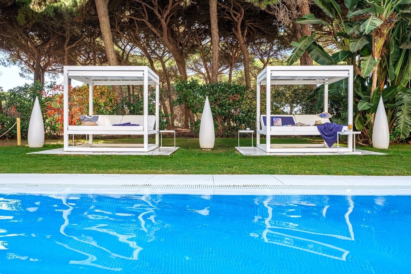 two white canopies sit next to a swimming pool