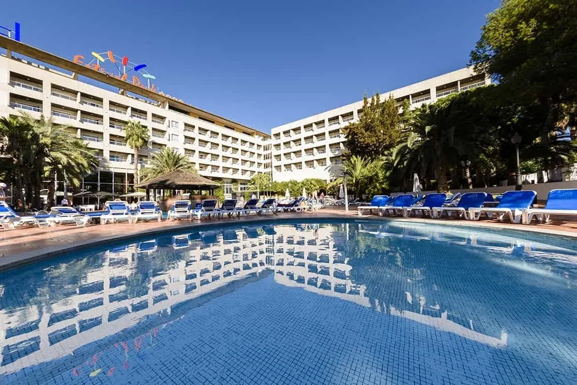 ESTIVAL: Corporativa Hotelgebäude mit Pool, Palmen und Liegestühlen.
