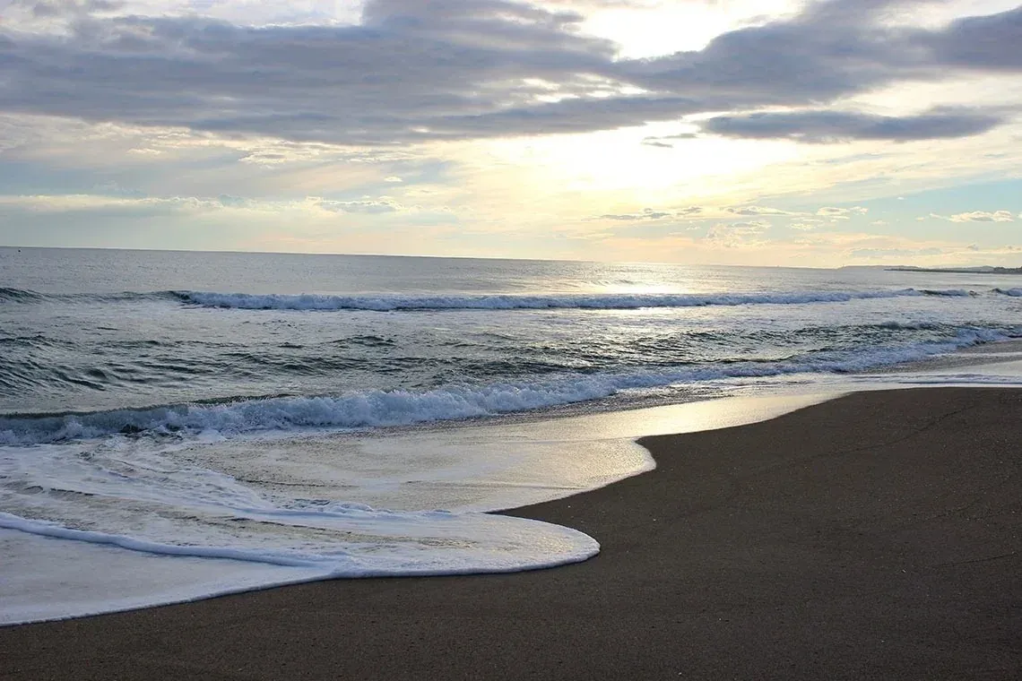 Plage paisible, idéale pour ESTIVAL: Corporativa. Vagues douces et sable noir.
