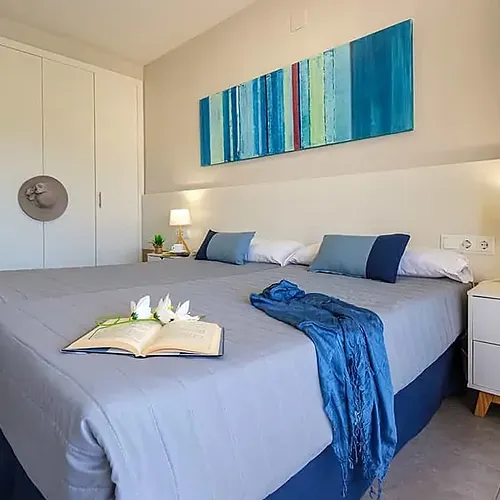 Habitació ESTIVAL: Corporativa amb dos llits, decoració moderna i quadres abstractes.