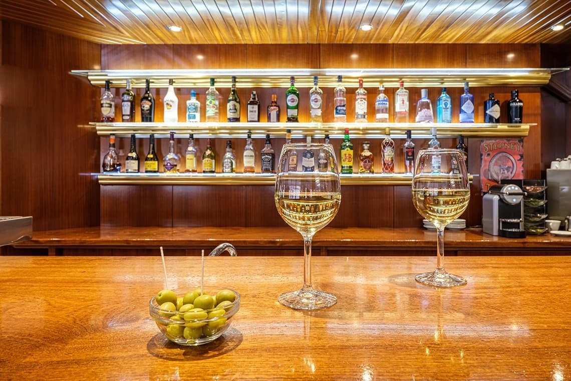 un bar amb dues copas de vi i un bol d' olives