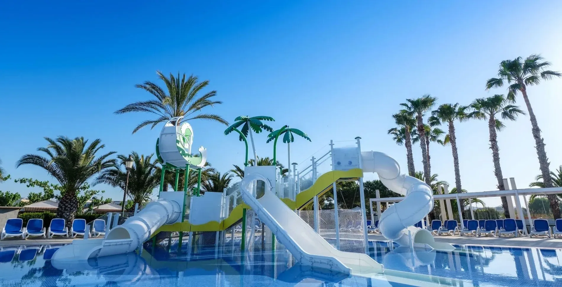 Parque acuático con toboganes y palmeras en Estival Vendrell Platja. Servicios | Estival Group | Web Oficial.