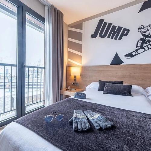 una habitació d' hotel amb una cama i un mural que diu 