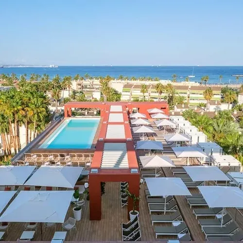 ESTIVAL Corporate hotel terrace with pool, loungers and sea views.
