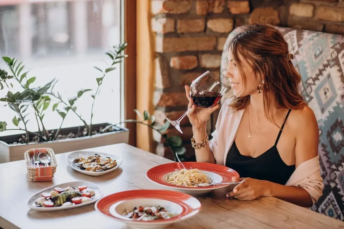 Woman enjoying wine at ESTIVAL: Corporativa hotel restaurant.