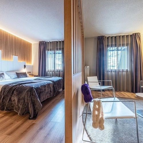 a hotel room with two beds and two chairs