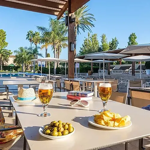 Beres i aperitius a la terrassa amb vistes a la piscina de l'Estival Eldorado Resort, Estival Group | Lloc Web Oficial.