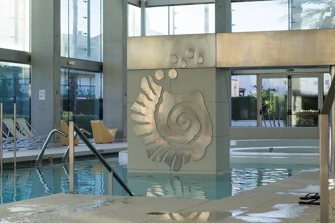 Piscina ESTIVAL: Corporativa amb escultura de caragol i gandules.