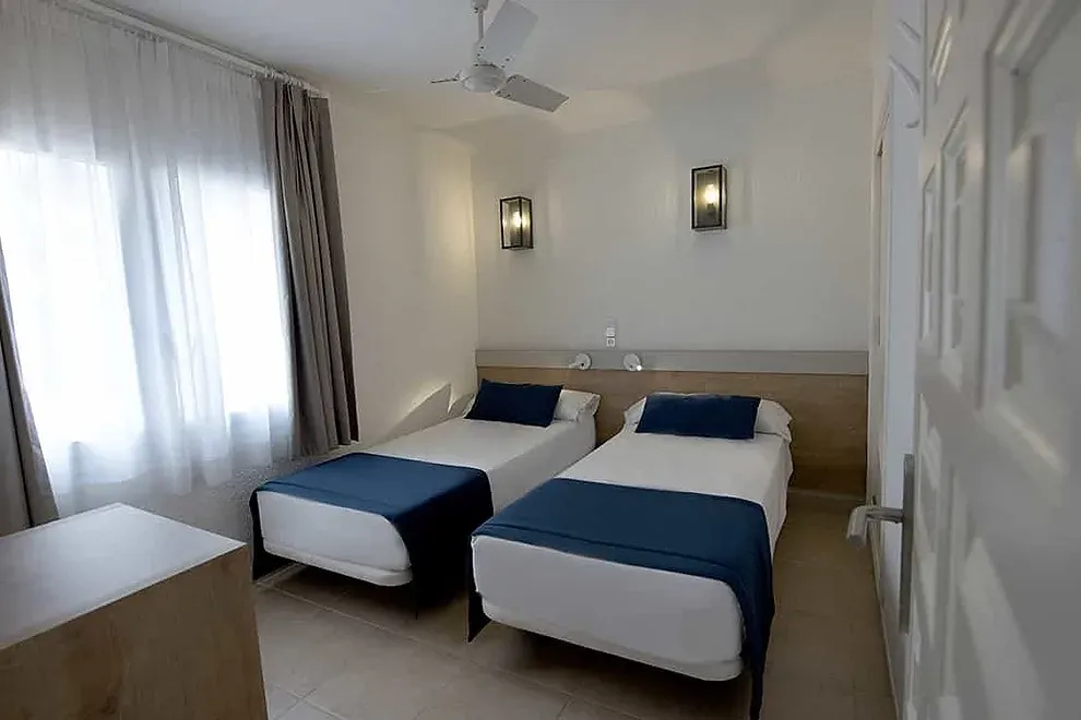 Habitación ESTIVAL: Corporativa con dos camas individuales y detalles en azul.