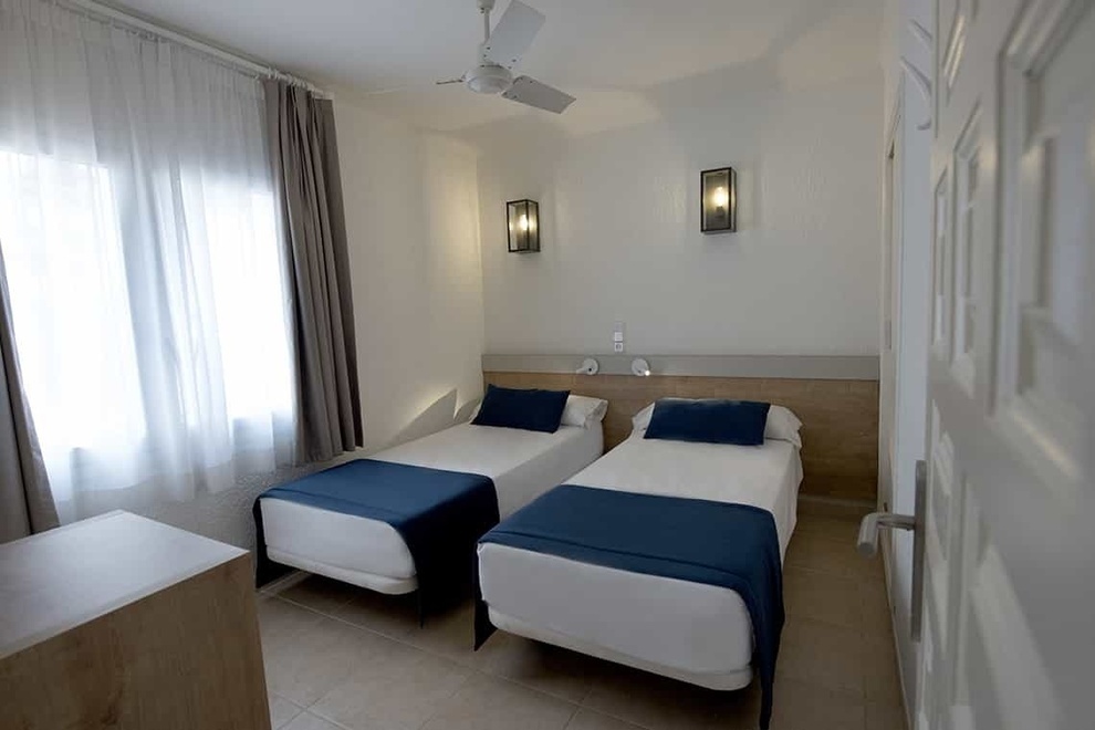 a bedroom with two beds and a ceiling fan