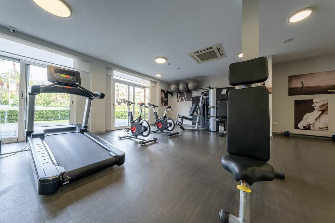 a gym with a treadmill and exercise bikes
