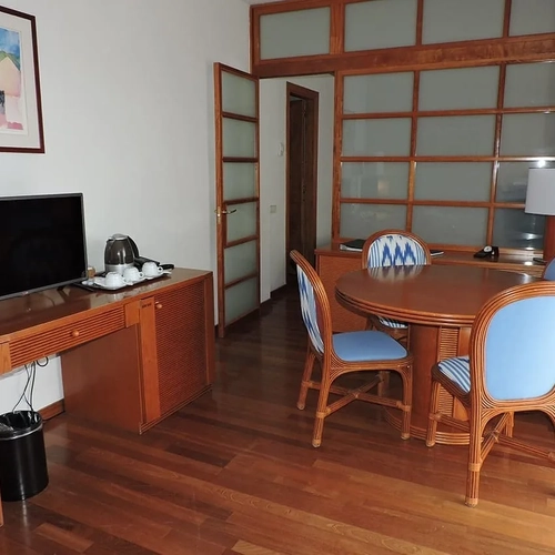 ESTIVAL Corporate room with TV, table and wicker chairs.