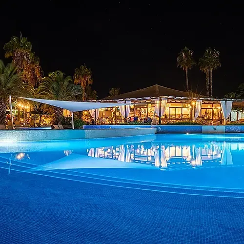 Estival Islantilla 4* | Poolside dining at night with palm trees, Huelva, Costa de la Luz.