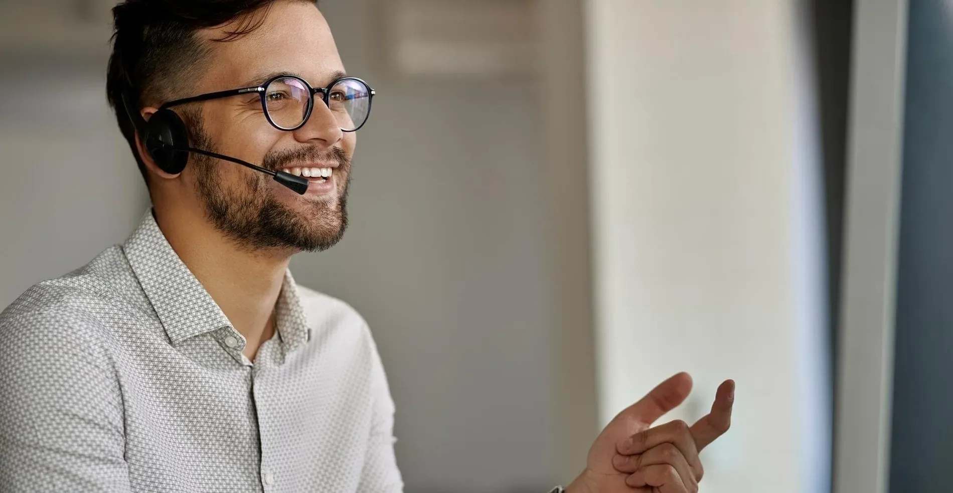 Oficinas Centrales Estival Group: Hombre con headset, sonriendo, en diálogo.