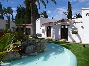 ESTIVAL: Corporativa, piscina serena junto a exuberante jardín y arquitectura blanca.