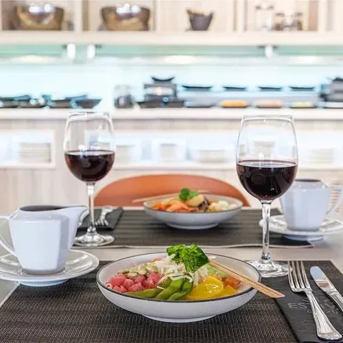Two red wine glasses, a poke bowl, and a creamer, perfect for ESTIVAL: Corporativa events.