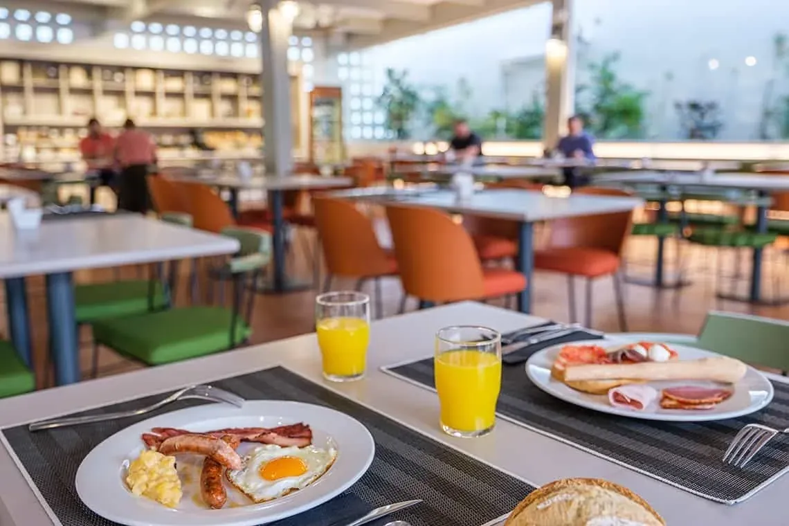 Petit-déjeuner buffet ESTIVAL: Corporatif. Œufs, bacon, saucisses et jus d'orange.