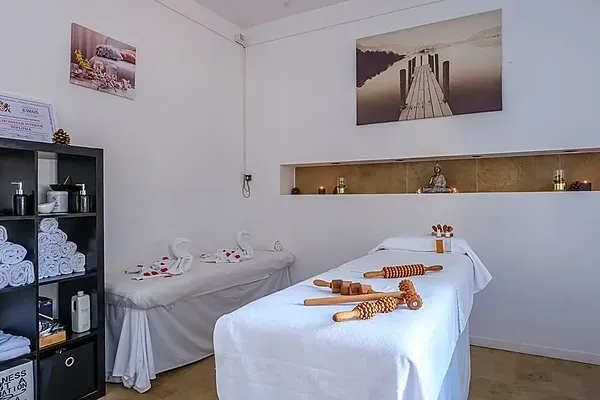ESTIVAL Geschäfts-Spa-Raum mit Massageliegen, Holzrollern und Zen-Dekor.