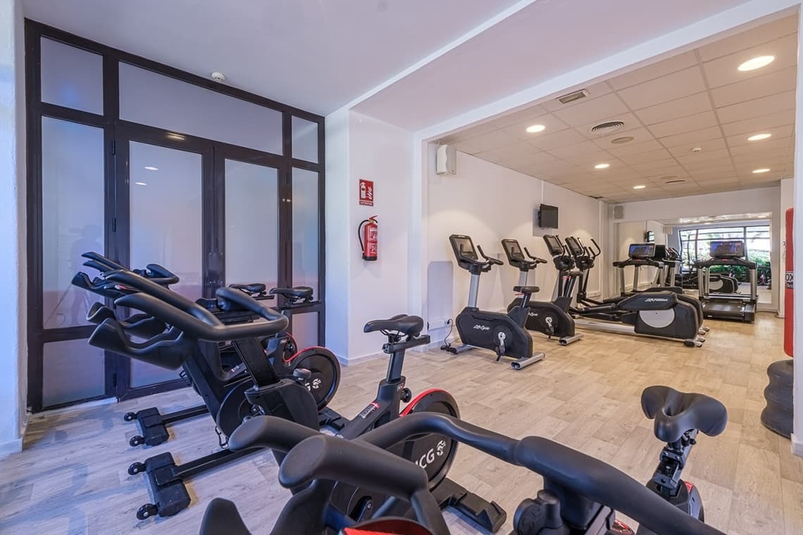 un gimnasio con muchas bicicletas y un extintor en la pared