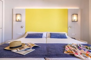 una habitación con una cama y una pared amarilla