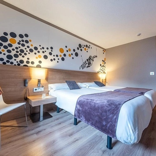 a hotel room with two beds and a chair