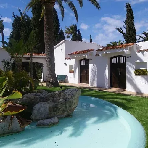 Estival Eldorado Resort:pati d'aigua i jardí davant d'edificis blancs mediterranis.